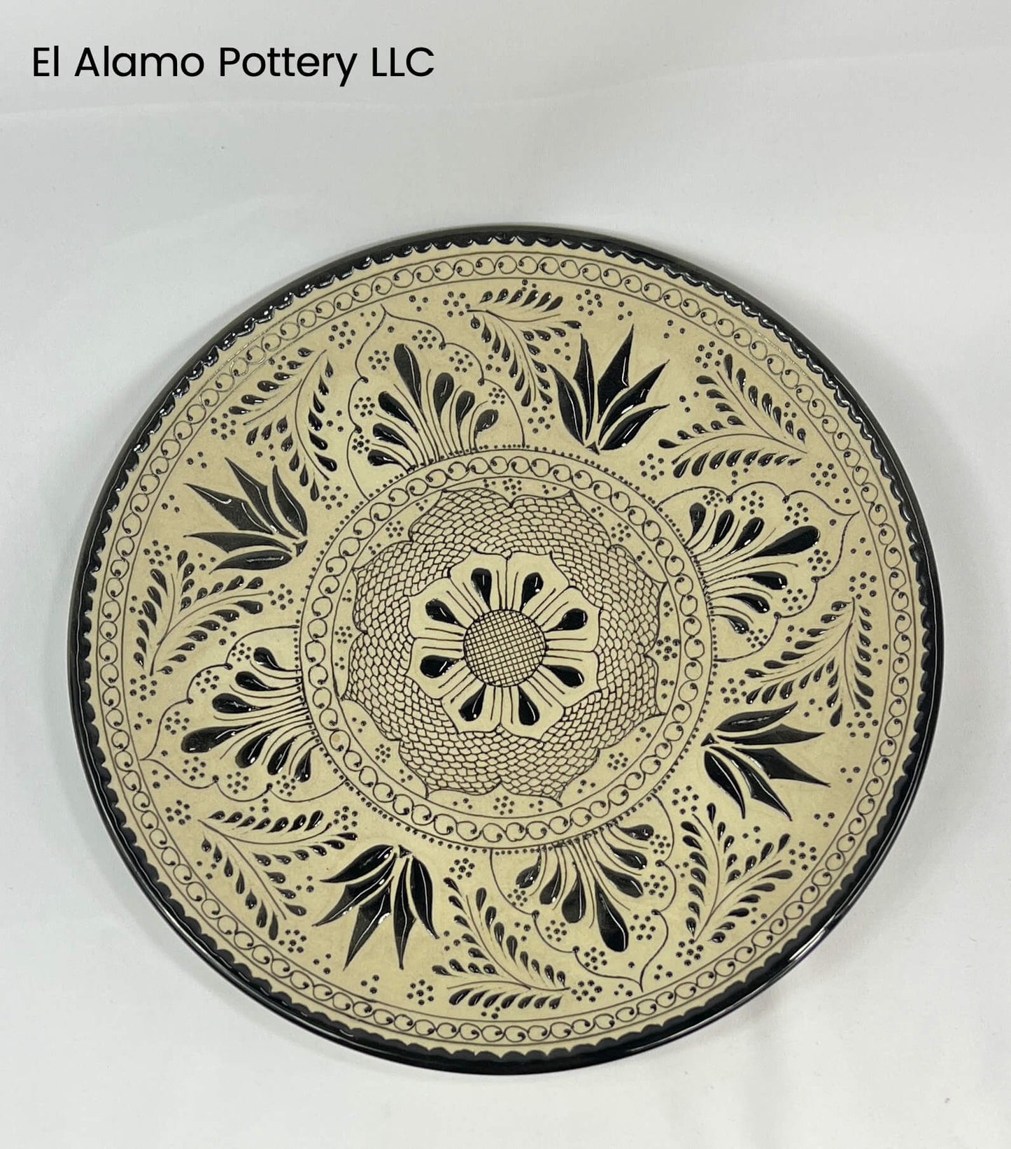 Plato llano artesanal de Talavera: Motivo botánico negro sobre arcilla natural (28 cm)